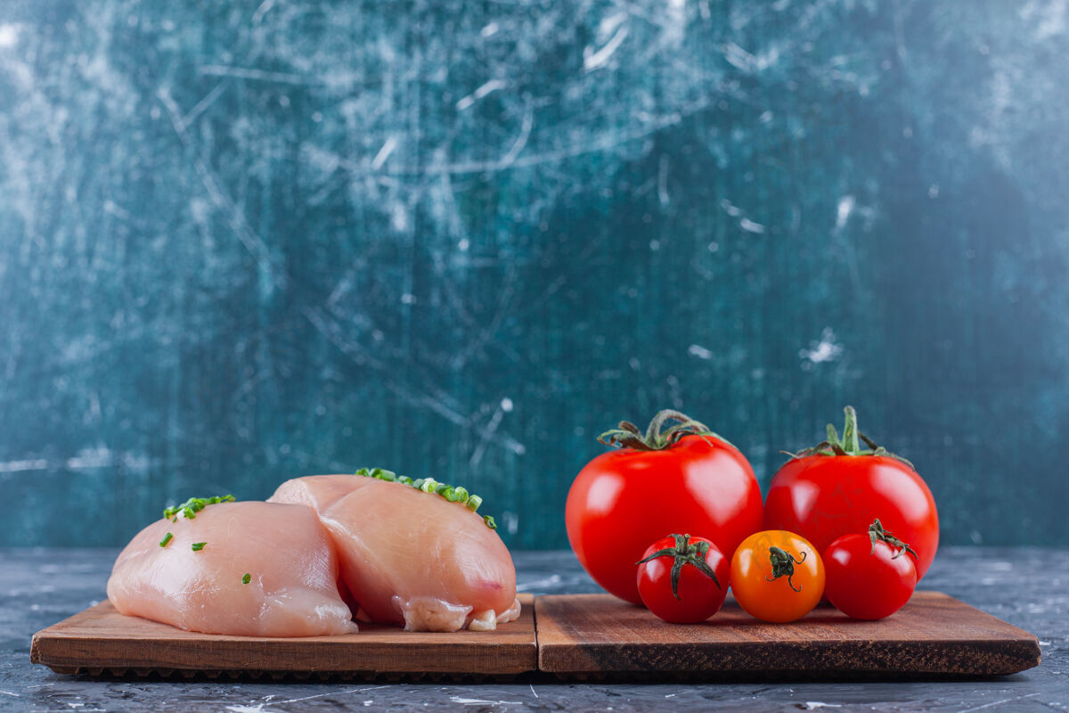 板鸡胸肉和西红柿放在蓝色的木板上营养蛋白质美味