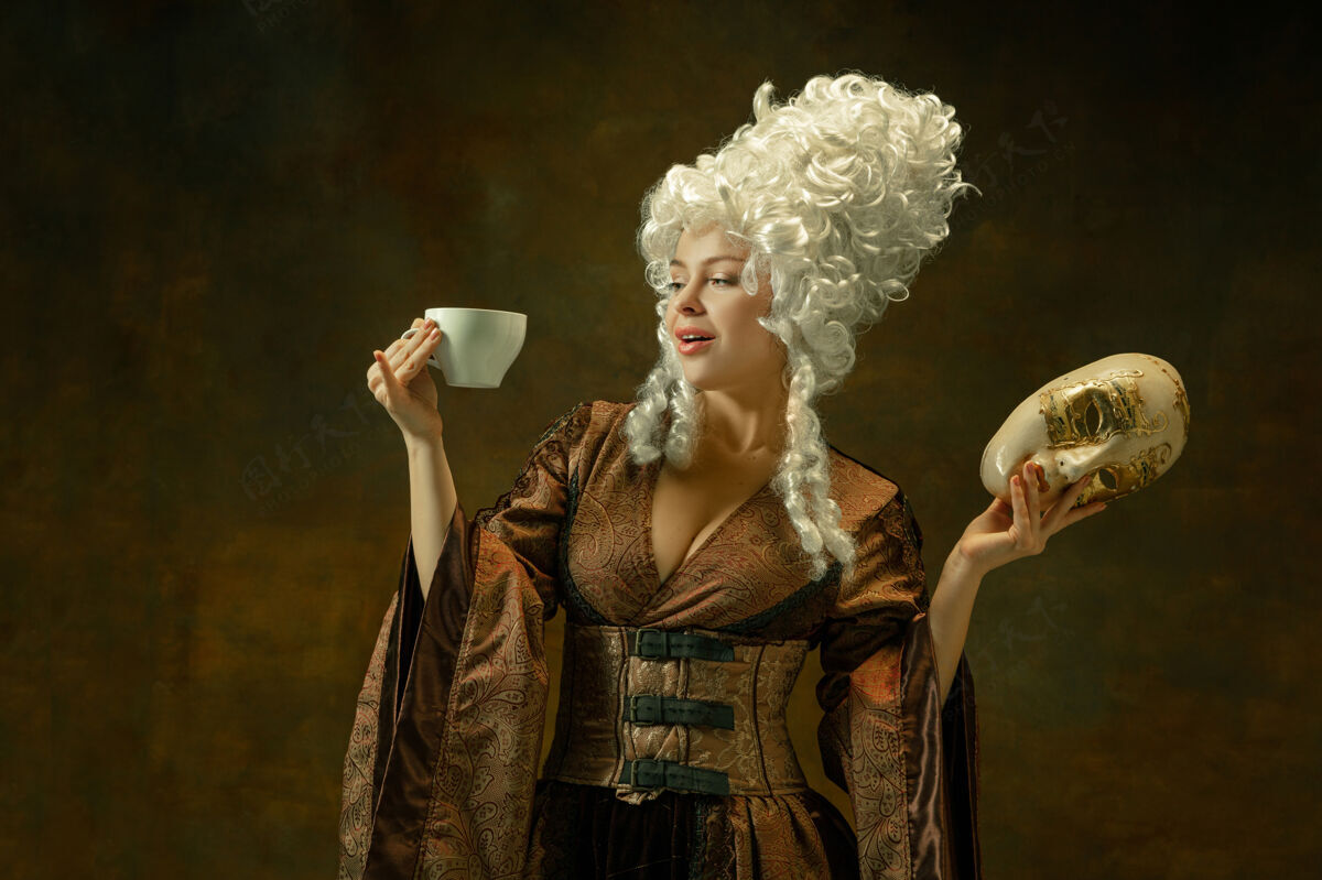 历史戴着面具喝咖啡在深色的墙上画着中世纪年轻女子的肖像 穿着棕色复古服装女模特是公爵夫人 皇室成员是时代 现代 时尚的比较概念紧身胸衣帽子情感