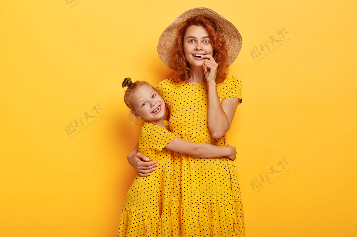 人快乐的红发母女穿着相似的衣服摆姿势女儿年轻快乐