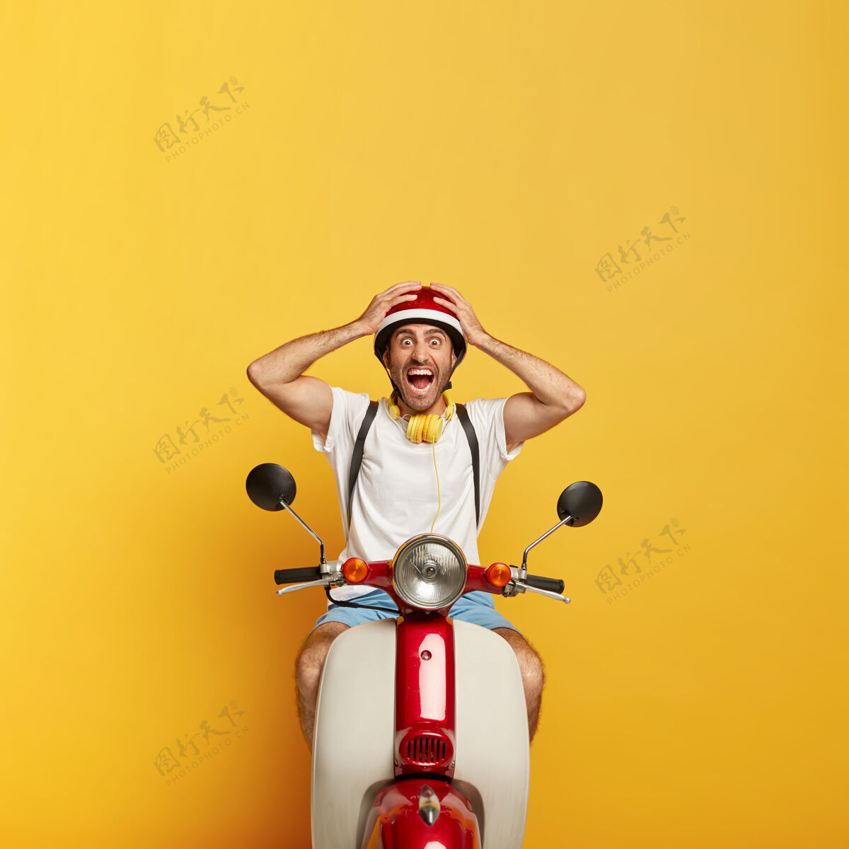 送货情绪化英俊的男司机骑着红色头盔的滑板车司机背包交通
