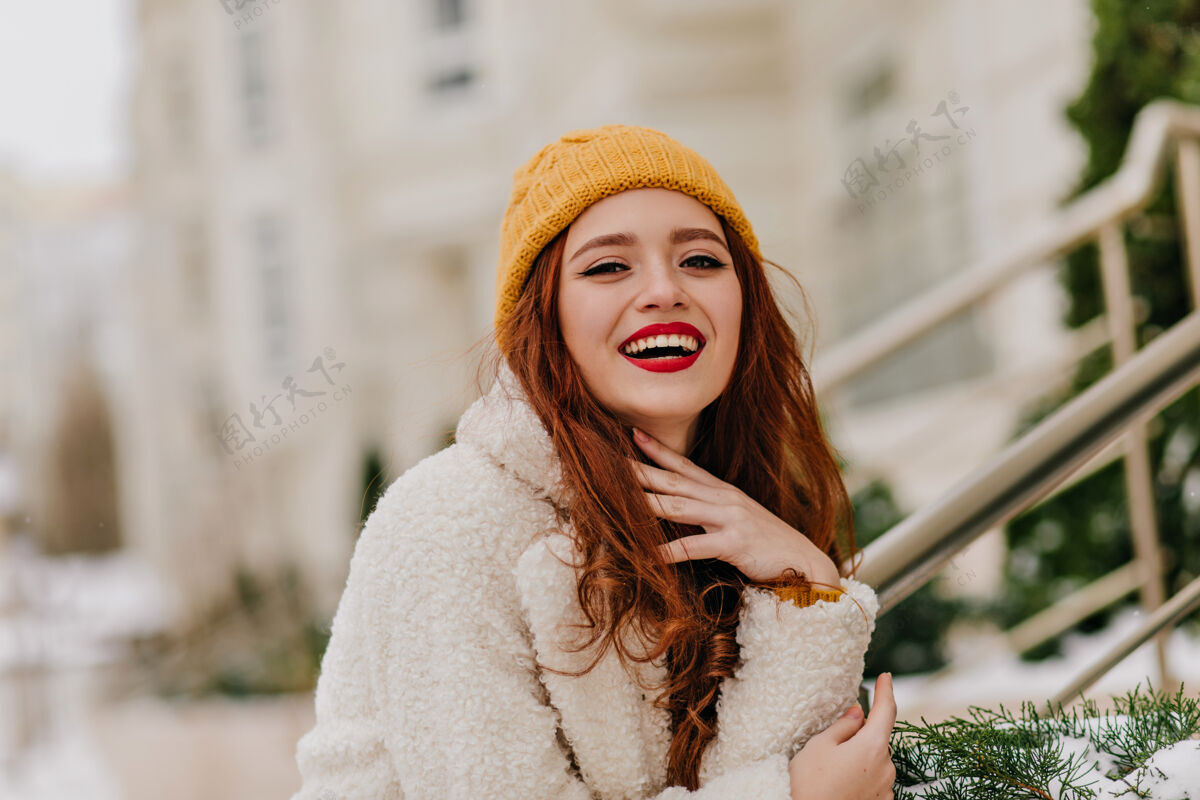 散步正面的红发女人在模糊的自然中欢笑精致的姜汁女孩在冬天的照片中微笑年轻女士外套