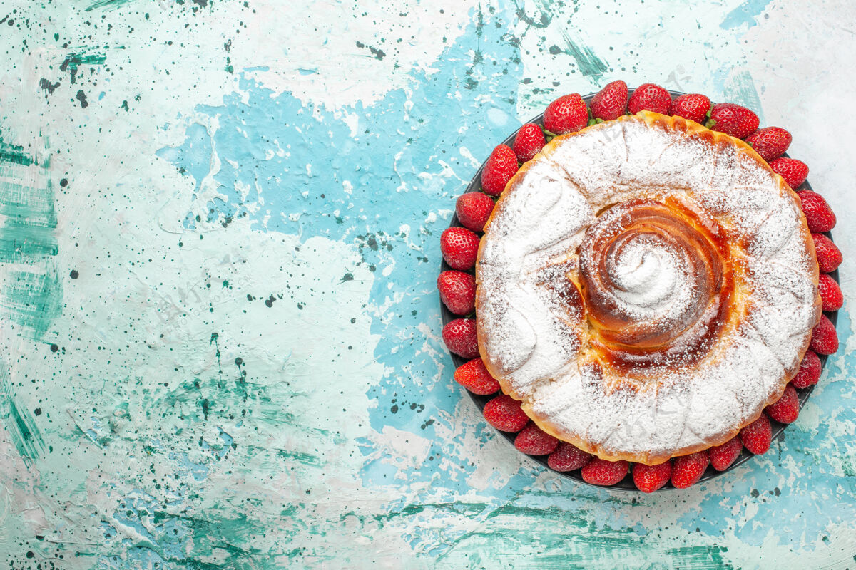 蛋糕顶视图糖粉蛋糕与新鲜的红色草莓在淡蓝色的表面饼干垃圾模式