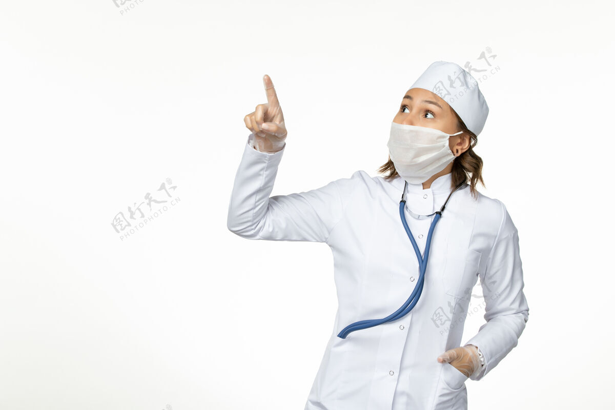 大流行正面图年轻女医生戴着无菌防护口罩 因冠状病毒直视白色表面的天空正面绝育疾病