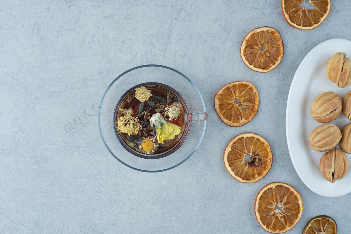 板甜甜的甜点配上橘子干和一杯凉茶 大理石背景高品质照片干橙子盘子糕点
