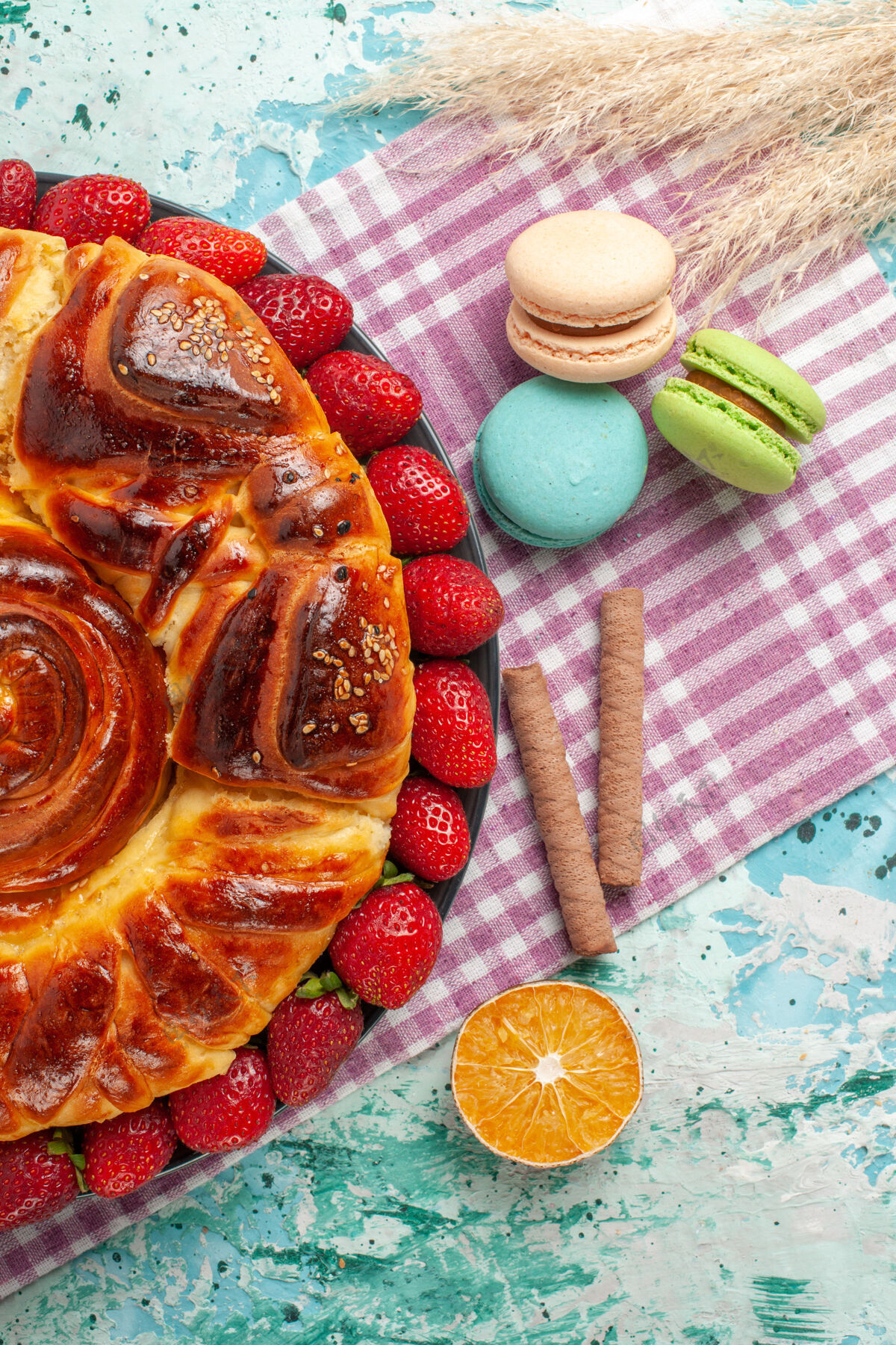 糖俯瞰草莓派与法国马卡龙在蓝色的表面食物顶午餐