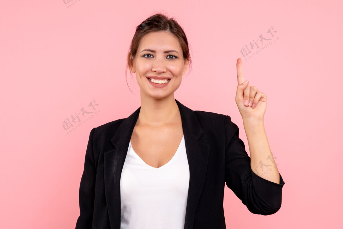商务女性正面图年轻女性穿着粉色背景的深色夹克夹克视角人物