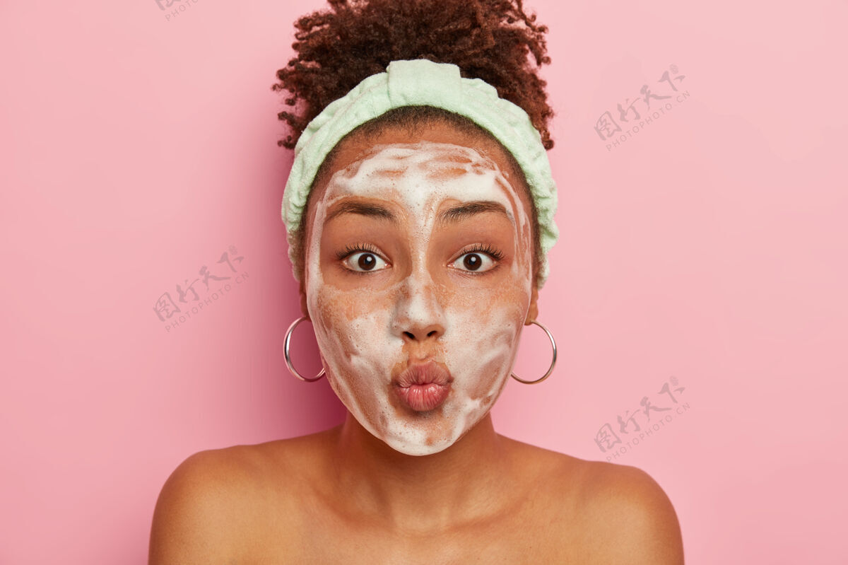 模特皮肤黝黑的少女有问题的皮肤 用泡沫涂抹在湿润的脸上 保持嘴唇折叠面部淋浴罗西