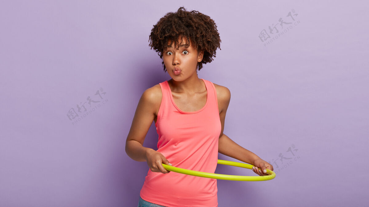 粉色运动型的民族女性 卷发 嘴唇圆润 转呼啦圈 身材好 穿着休闲的粉色背心 有运动的身材运动非洲健康