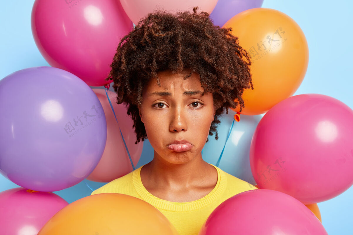 清爽悲伤绝望的非洲女人的头像夹着下唇 在派对上心情不好 没有朋友想在大公司庆祝她的生日 在彩色气球旁拍照破坏了节日不快乐节日理发