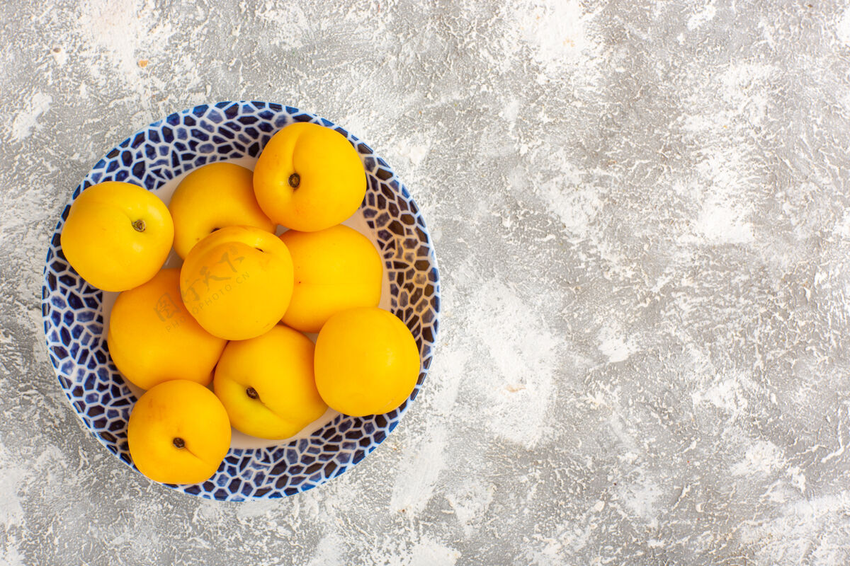杏顶视图新鲜甜杏黄色水果盘内白色表面里面甜柠檬