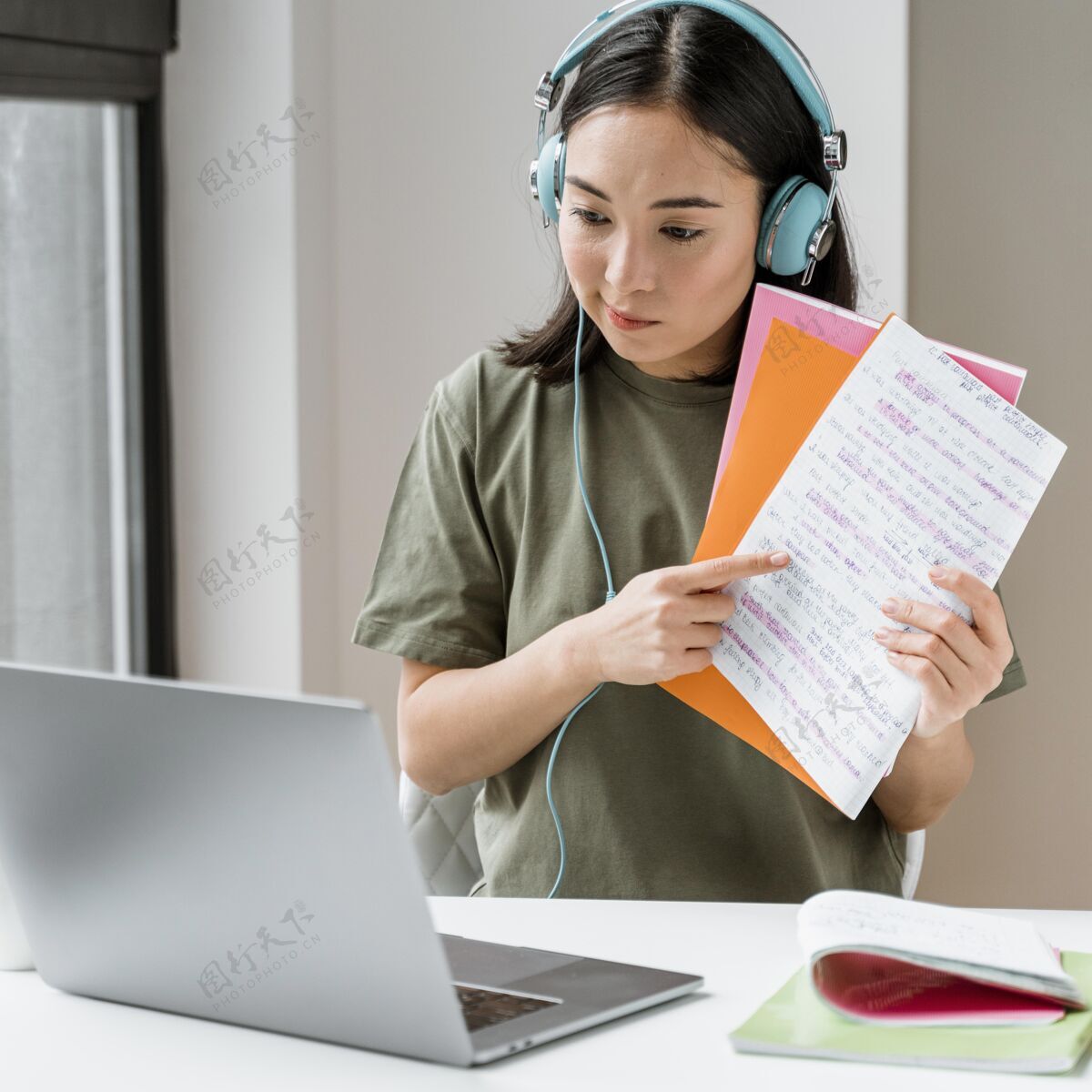 科技戴着耳机的女人在笔记本电脑上进行视频通话笔记本电脑书籍年轻人
