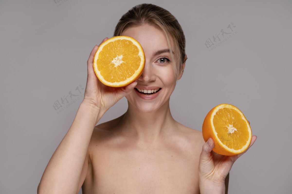 护理拿着一半橘子的漂亮女人女性时尚美女