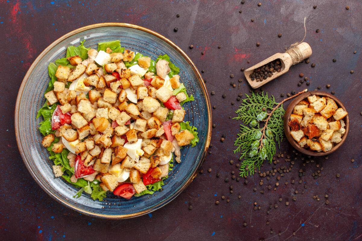 豆类在黑暗的桌子上俯瞰美味的凯撒沙拉和小拉斯克午餐食物美味