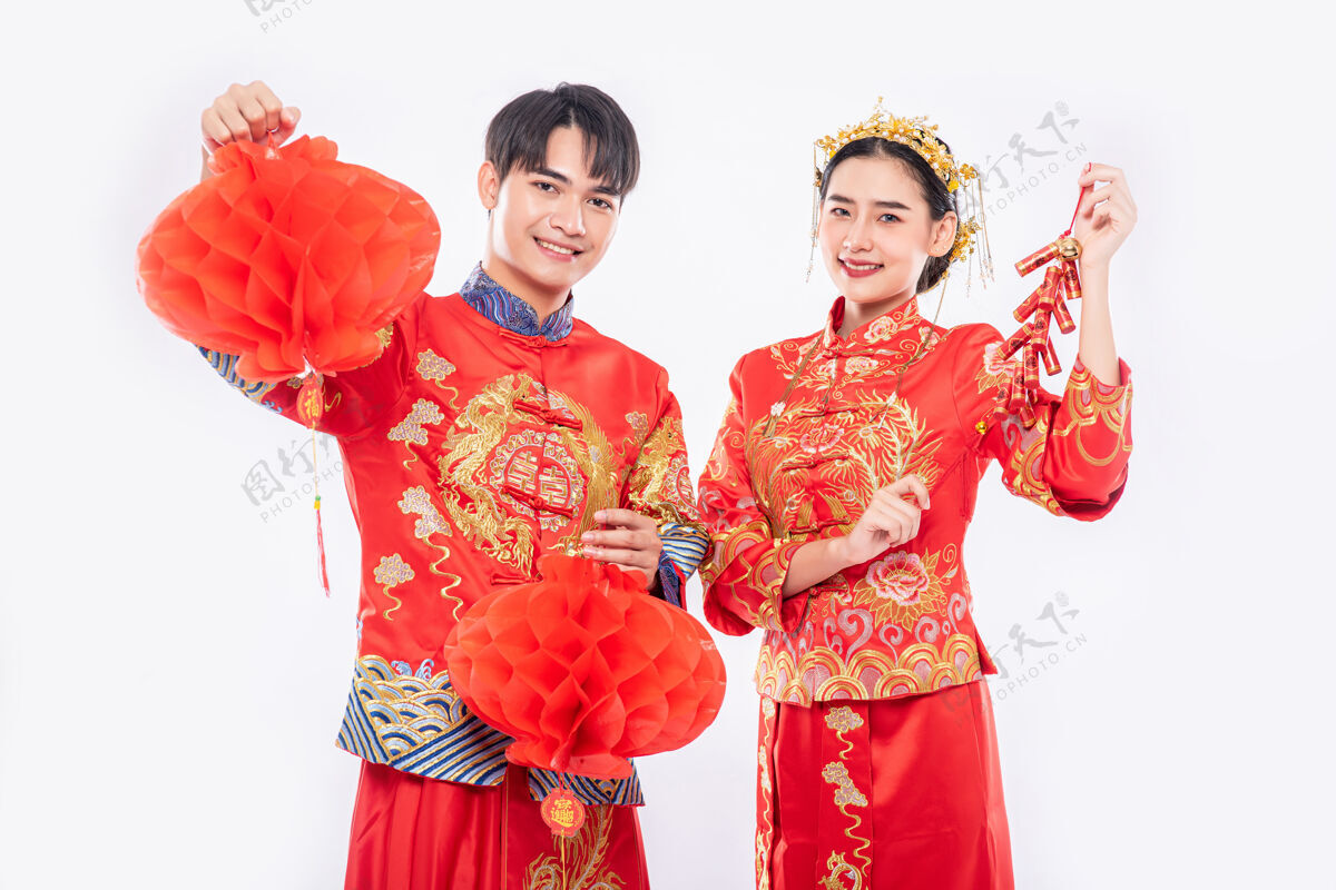传统节日男男女女穿旗袍西服 用红灯笼和鞭炮庆祝中国新年女孩中国民族鞭炮
