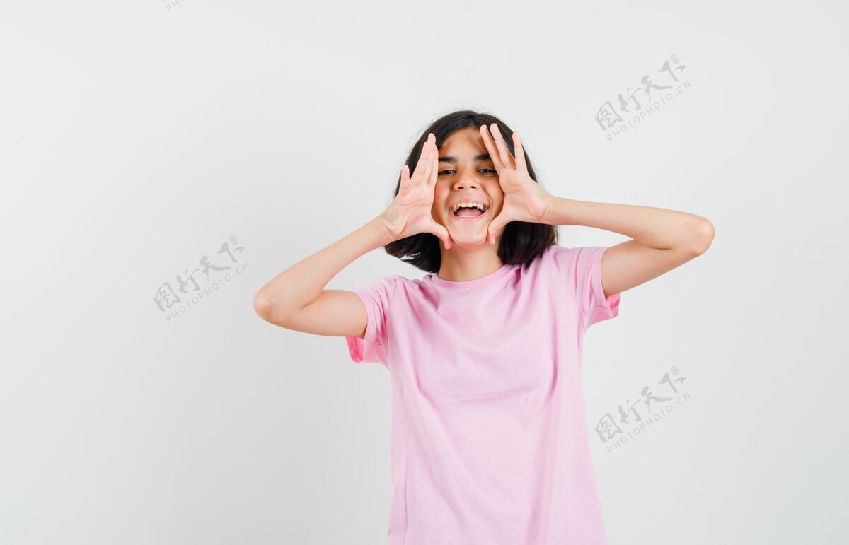 美丽穿着粉色t恤的小女孩大声喊叫或宣布某事 看上去很高兴 正面照粉色可爱成人