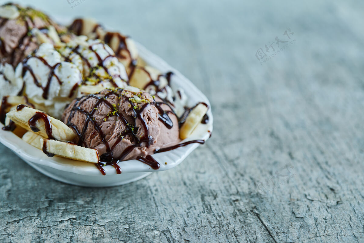 冷的雪糕加香蕉 巧克力和洒在白色盘子上冰淇淋甜的巧克力