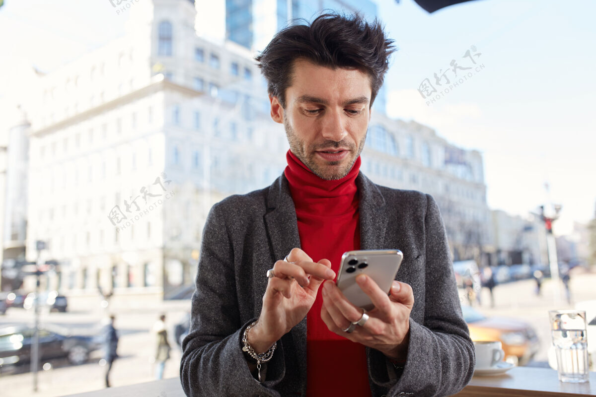 手一张横幅照片 年轻英俊的黑发男子身着正装 站在城市背景上用手机输入信息男正式短裤