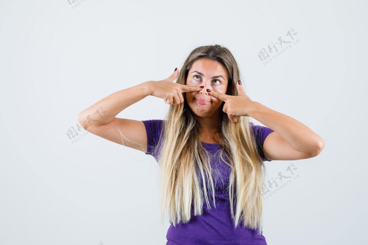 爱一位金发女士穿着紫色t恤 手指放在鼻子上 看起来很有趣正视图女士女人人