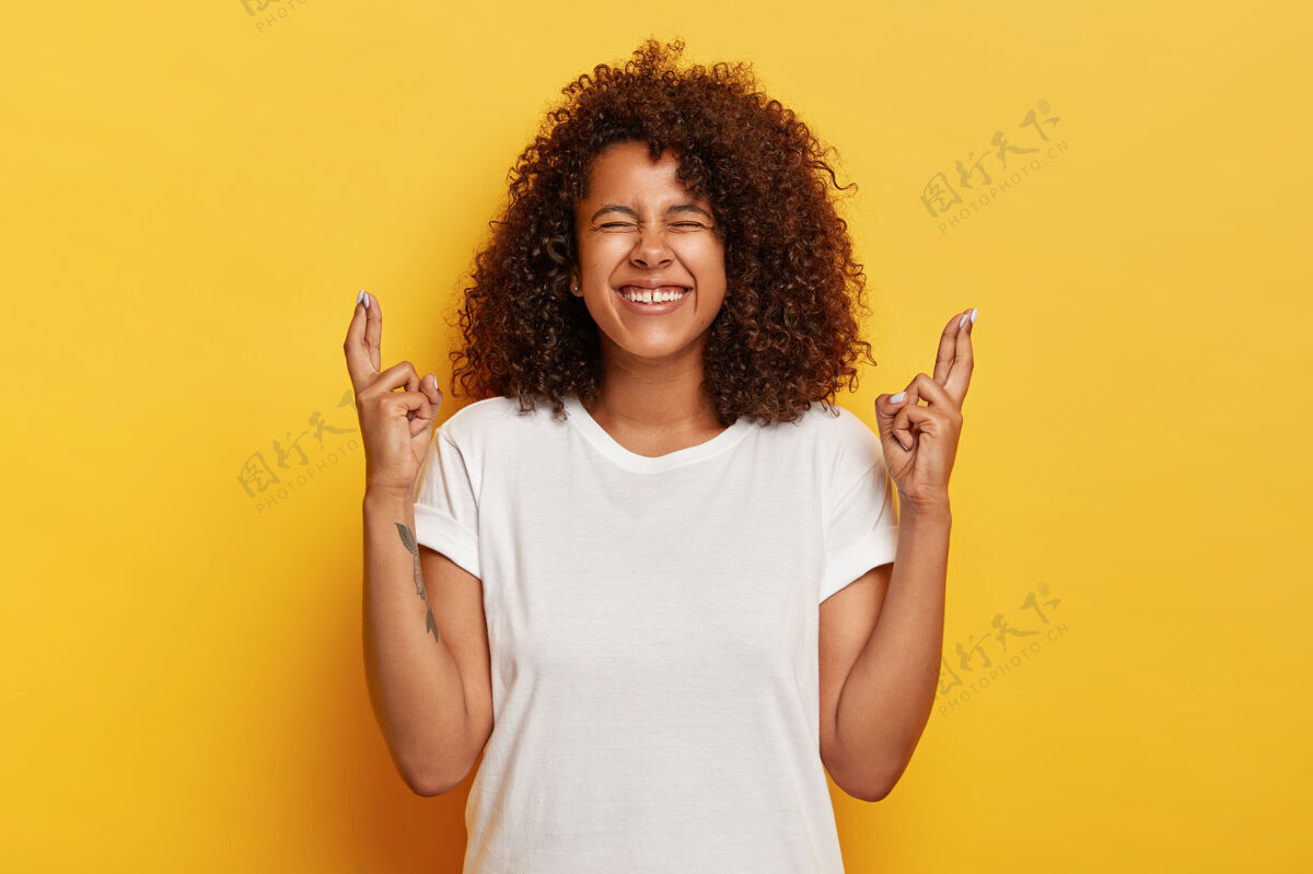 肢体语言积极的卷发女性交叉手指纹身青少年墙壁