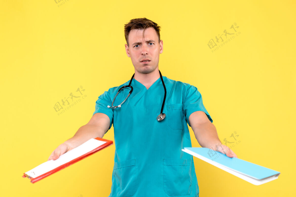 护士黄色墙上的男医生的正面图人医学听诊器