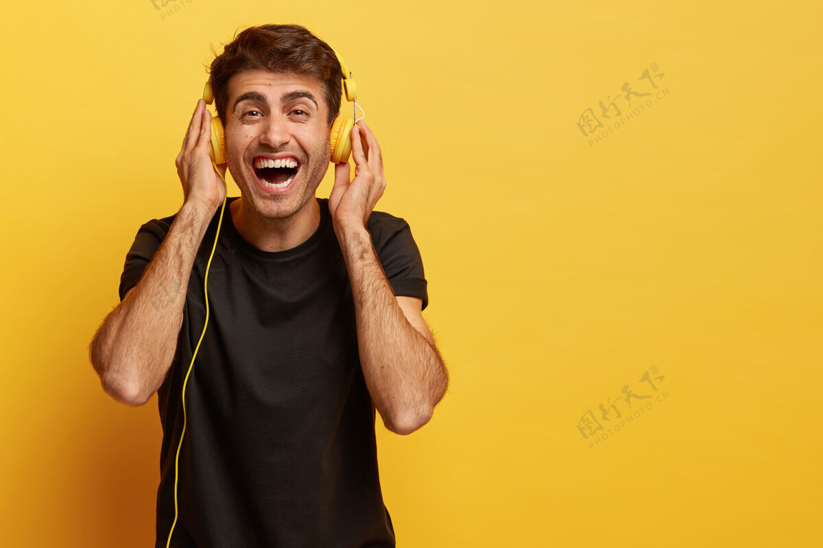 曲目快乐的男性梅洛曼享受新耳机的悦耳声音 聆听喜爱的音乐使用歌手水平