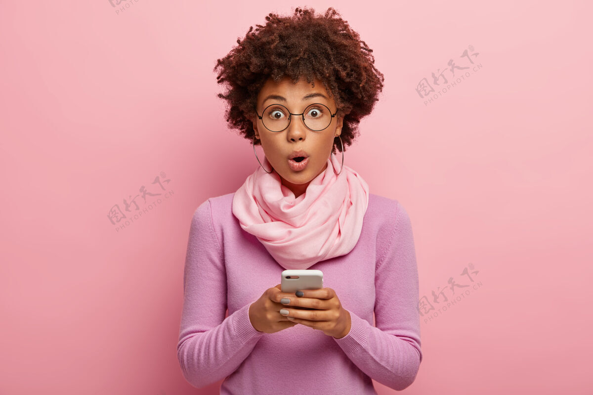 印象表情惊艳的黑皮肤黑人女博主在手机上公开美国民族姿势