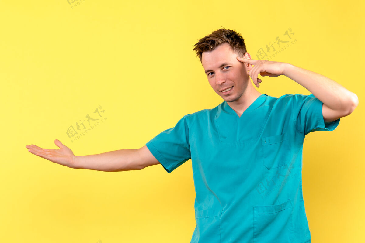 人黄色墙壁上微微微笑的男医生正面图男医生男人成人