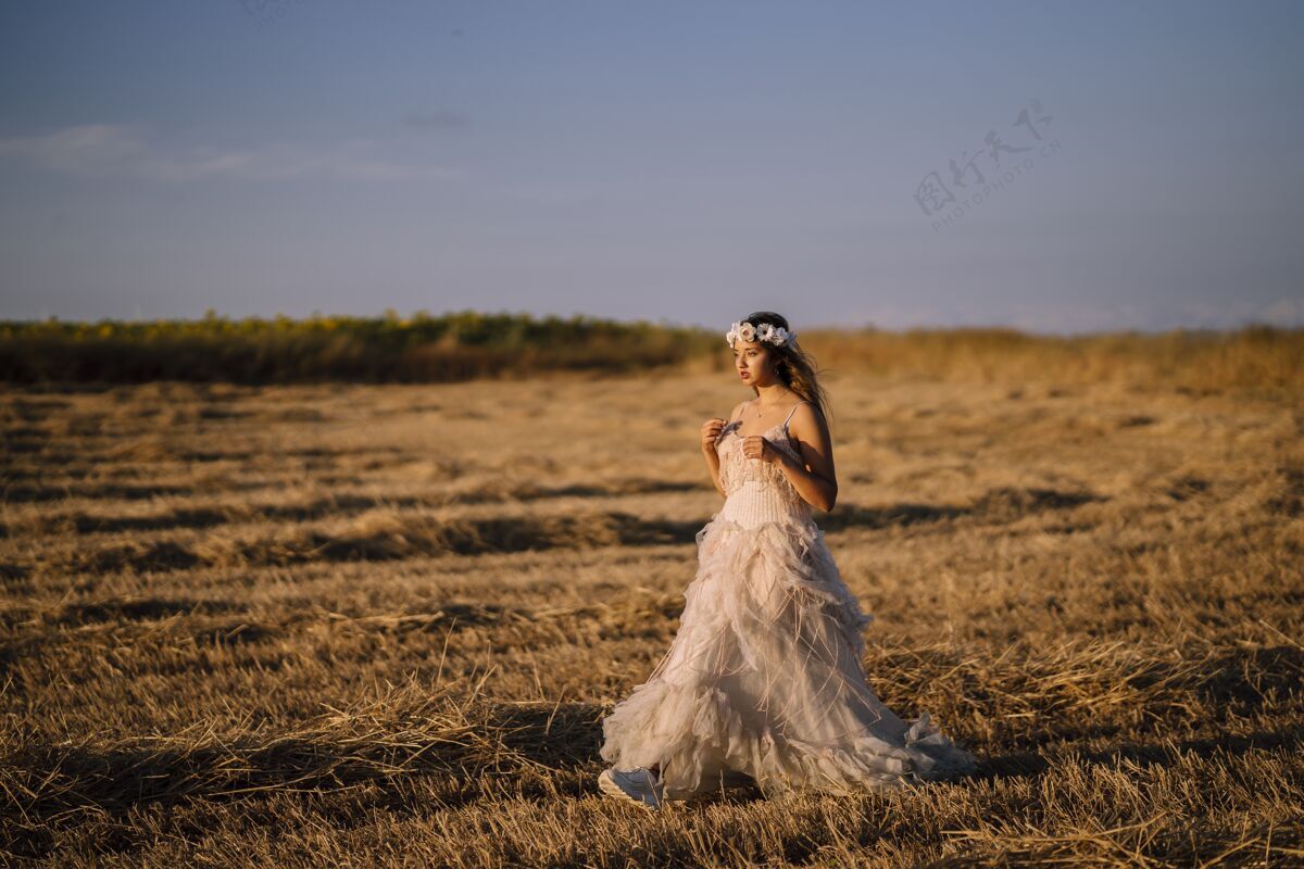 女人一个穿着白色裙子的年轻白人女性在田野里摆姿势的水平镜头农场高加索草地