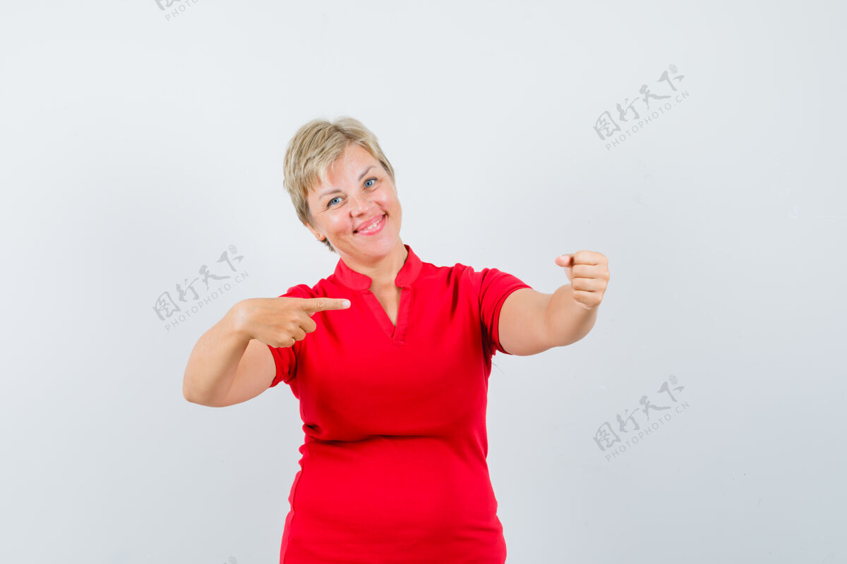 女性成熟的女人指着旁边 假装拿着一件红色t恤 看起来很高兴红色女人信心