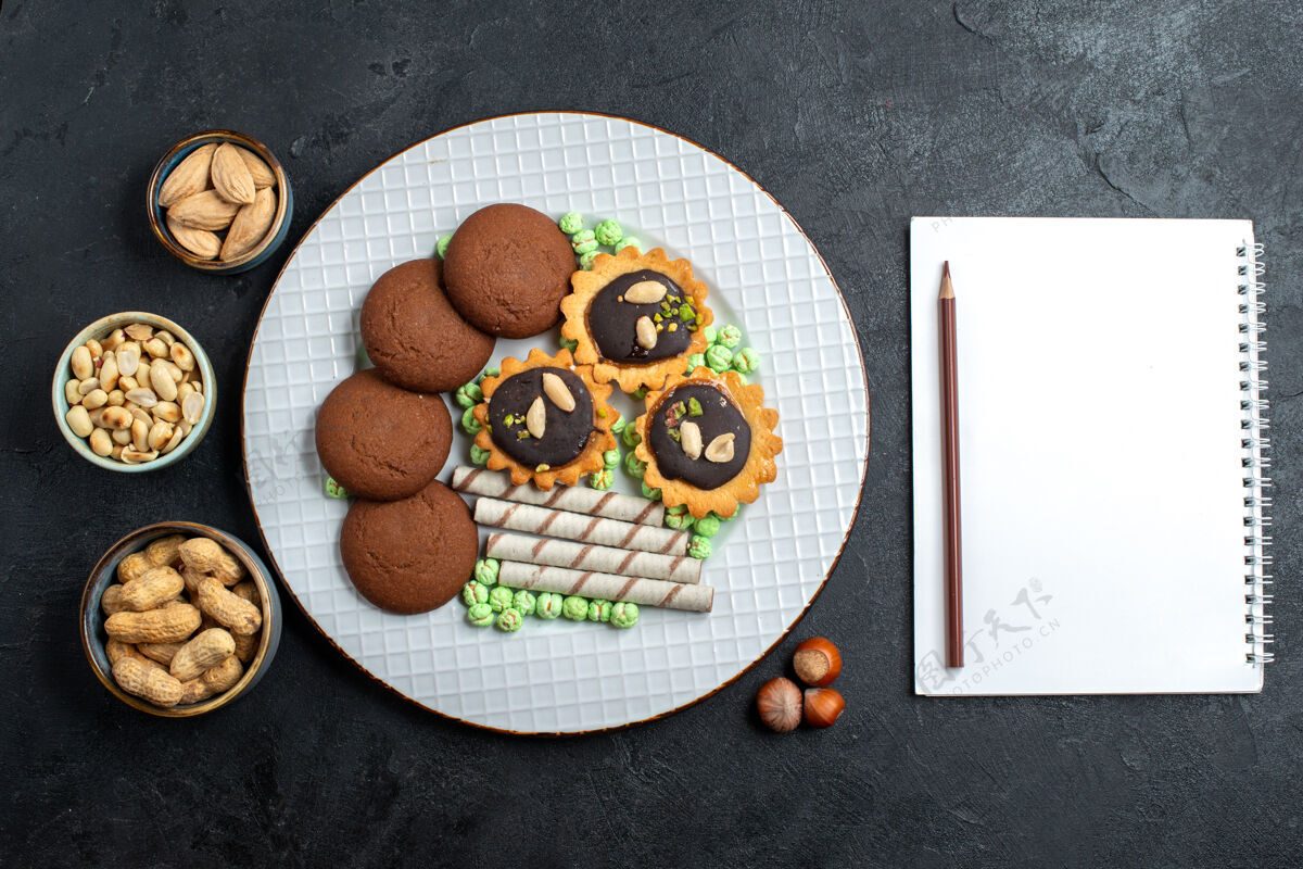 坚果顶视图不同的巧克力饼干与坚果在深灰色表面糖饼干甜蛋糕派饼干设备饼干视图