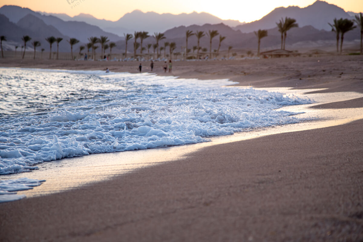 海滩美丽的荒芜沙滩在夕阳与海浪的背景下的山脉埃及沙滩地中海