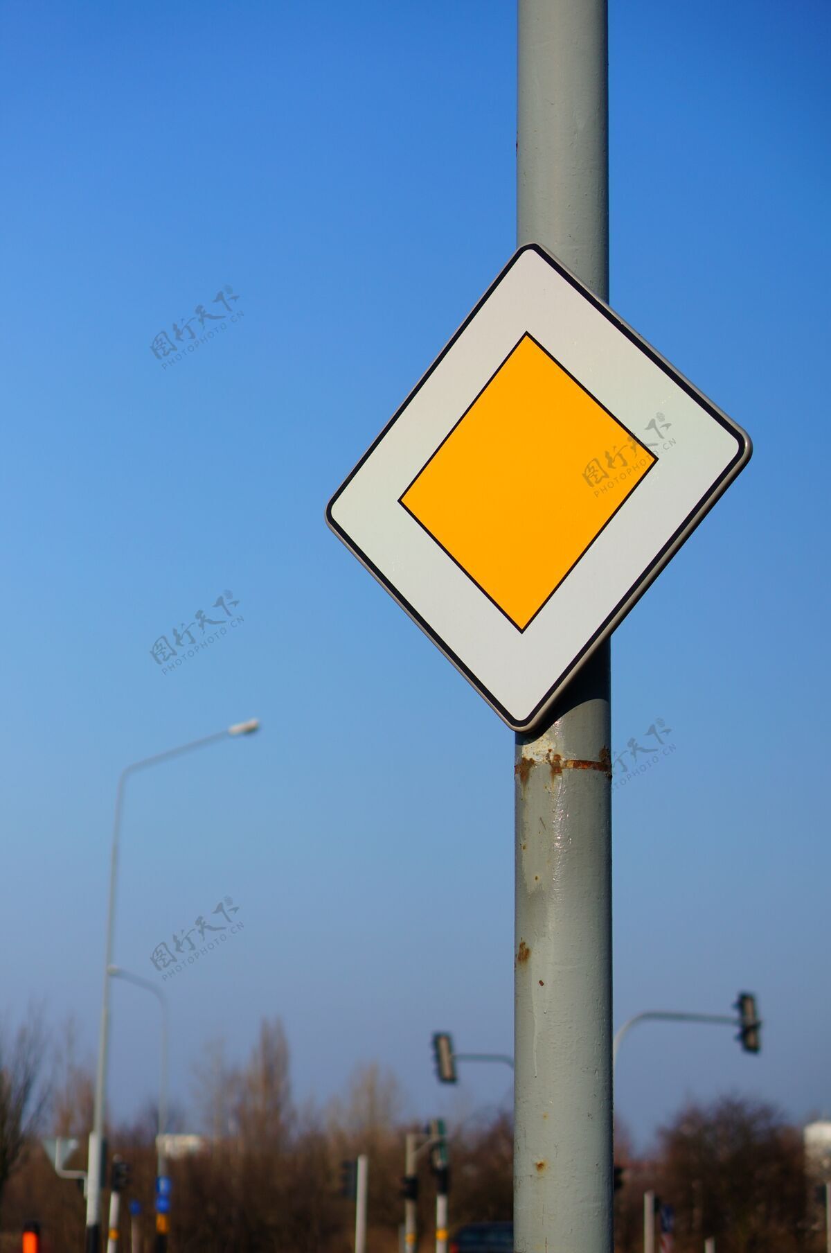 驾驶在晴朗的蓝天下低角度拍摄优先交通标志警告汽车安全