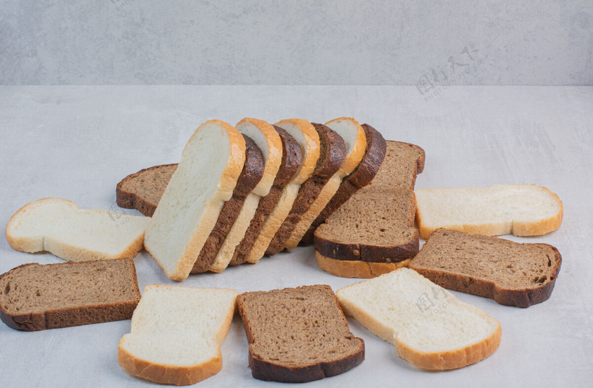 糕点新鲜的白色和棕色面包片放在大理石背景上面包房棕色白色