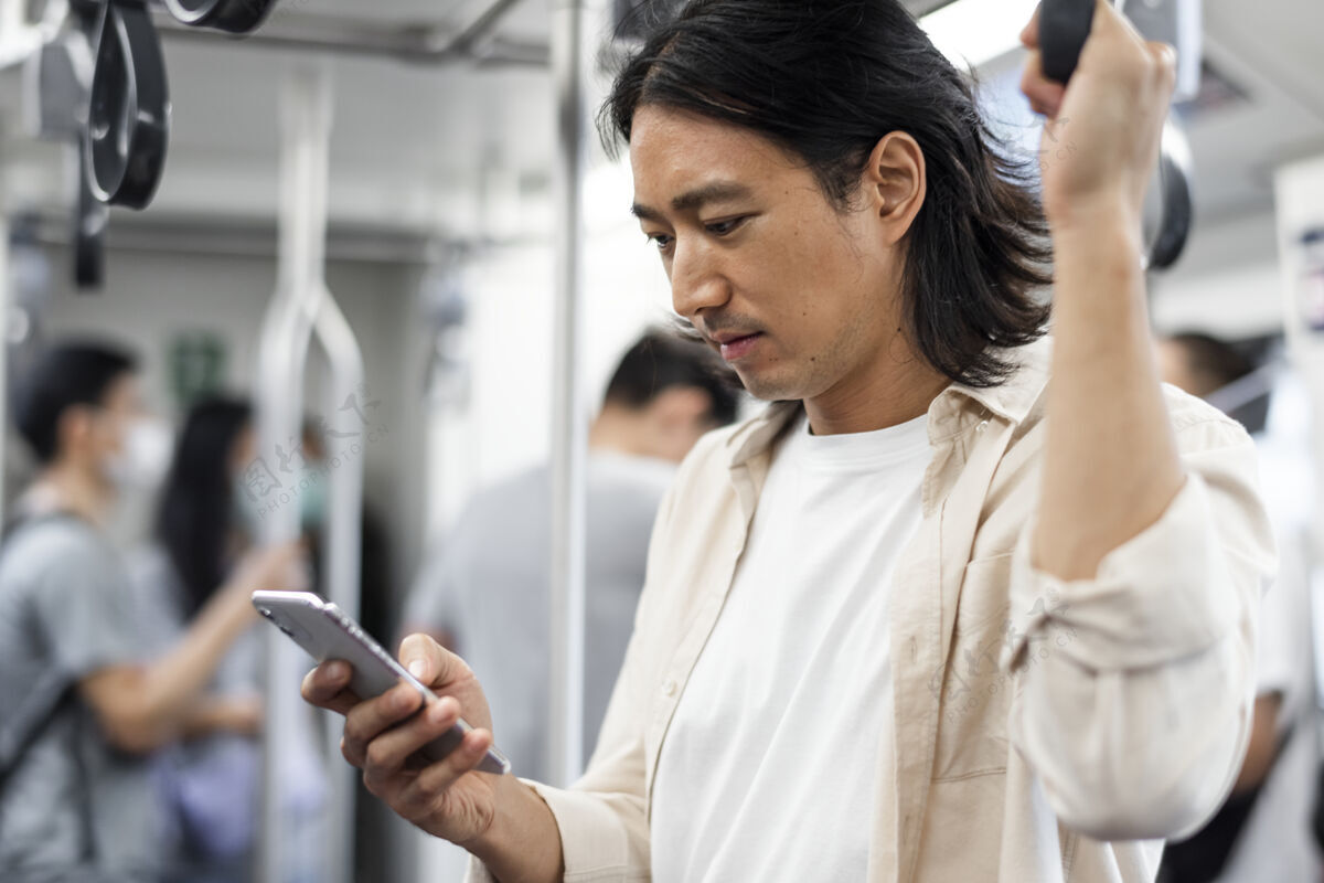 移动一个日本男人在火车上玩手机地铁火车短信
