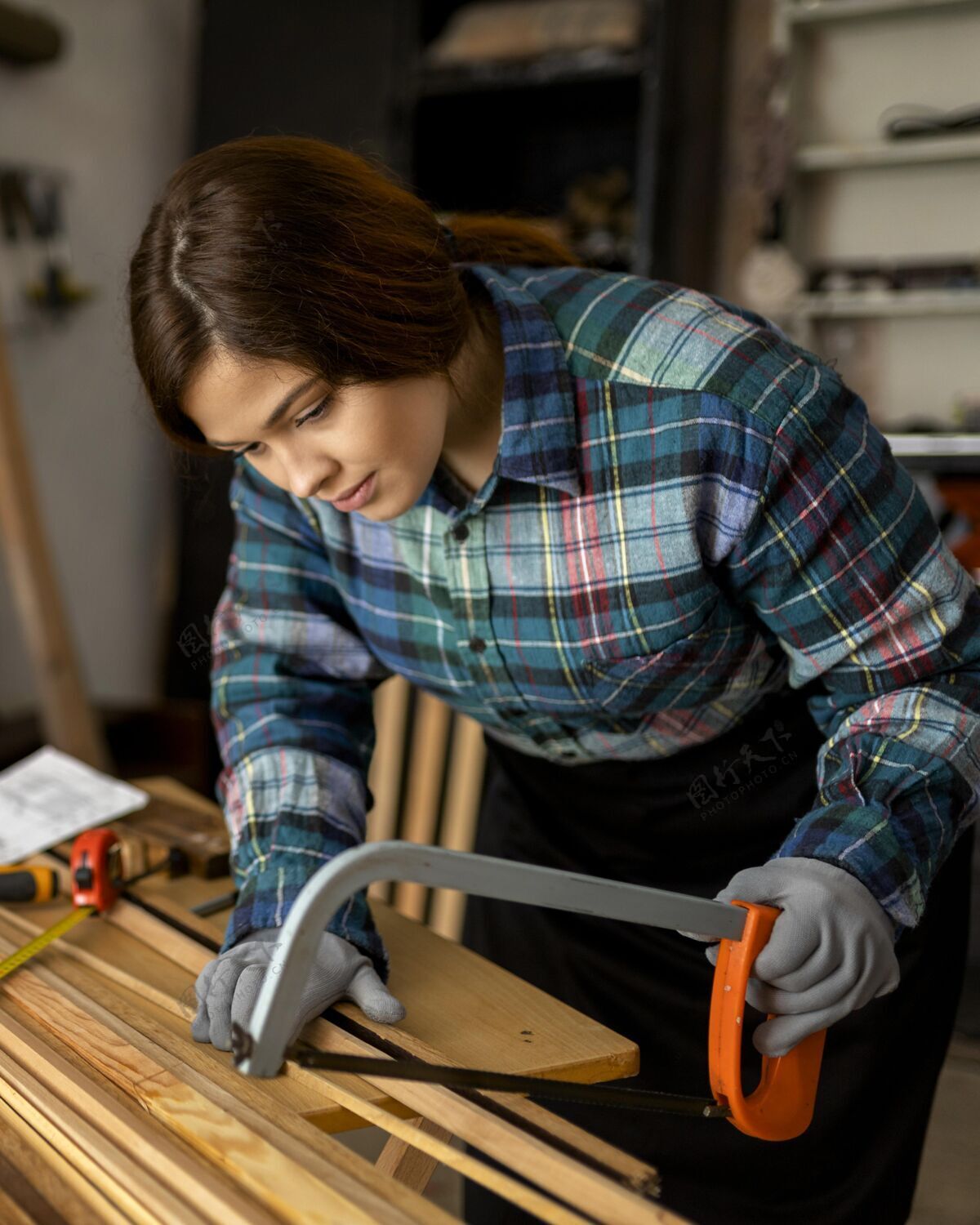 锯女人用锯切工作事件木板
