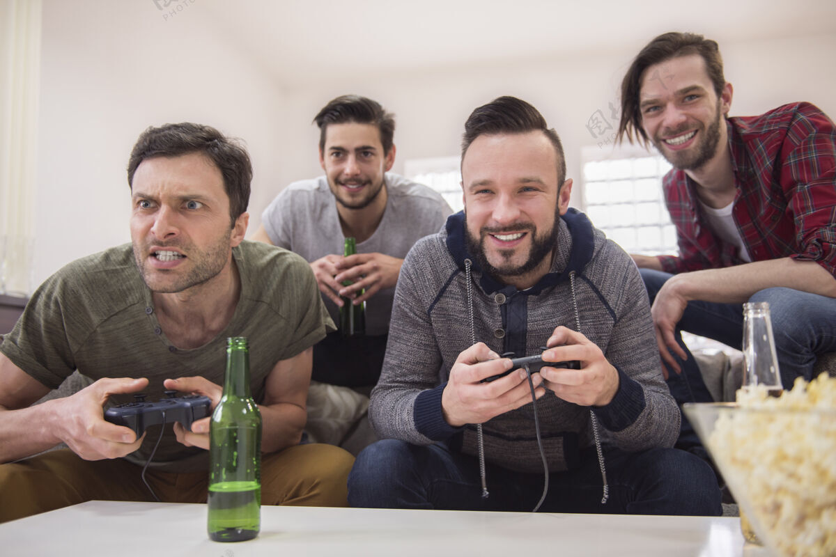 玩朋友们喝啤酒玩电子游戏电视享受乐趣