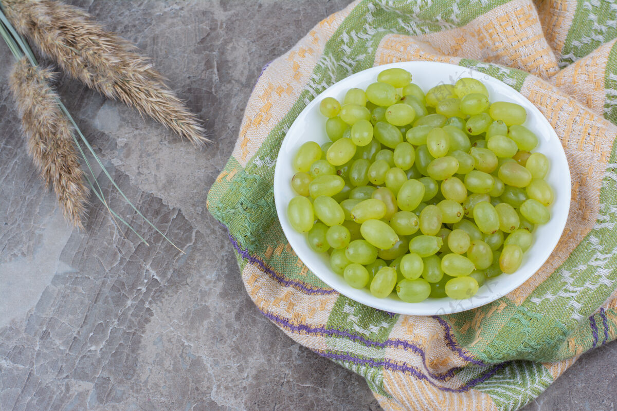 水果一碗绿葡萄放在五颜六色的桌布上植物自然桌布