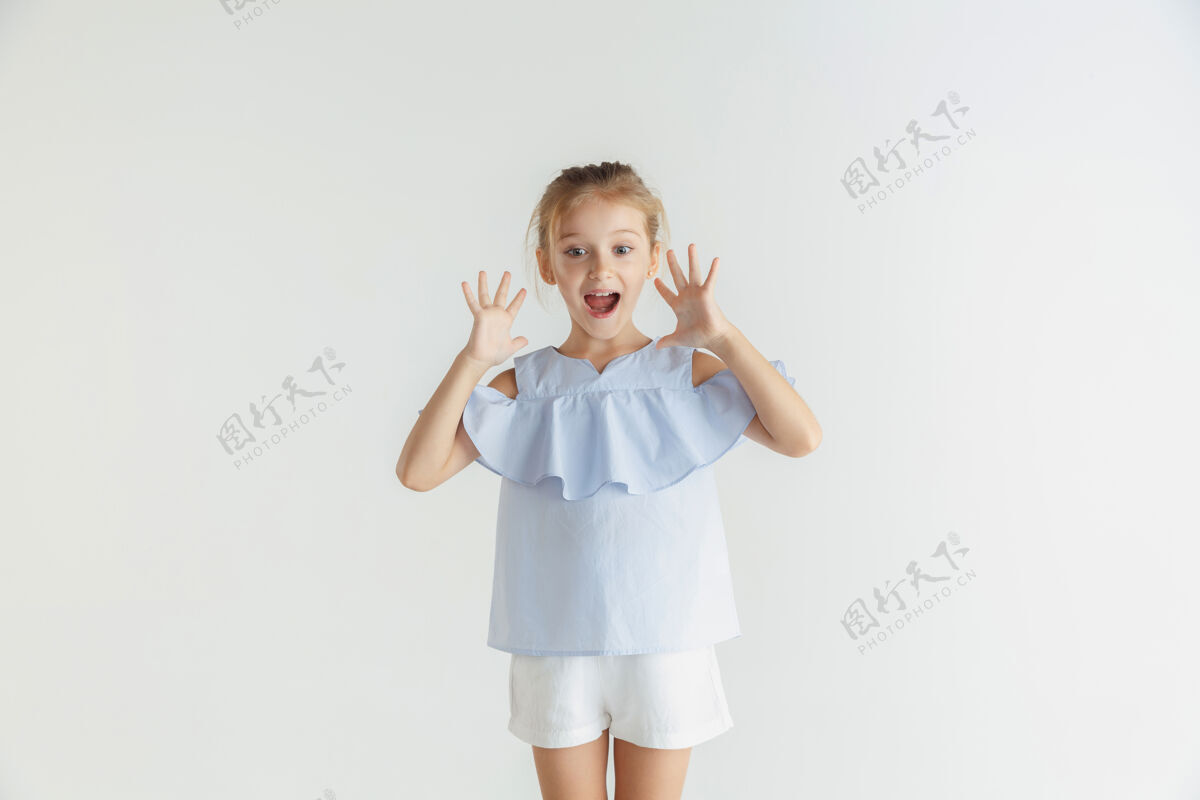 小时尚的微笑小女孩 穿着休闲服 在白色的工作室背景下摆姿势白人金发女模特人类的情感 面部表情 童年 销售震惊 惊讶表情面部休闲