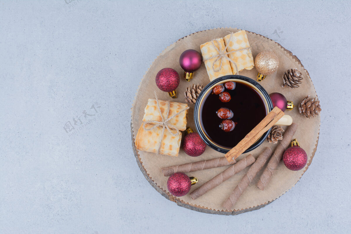 杯子一杯茶 上面放着玫瑰果 饼干和小装饰品杯子圣诞节棍子