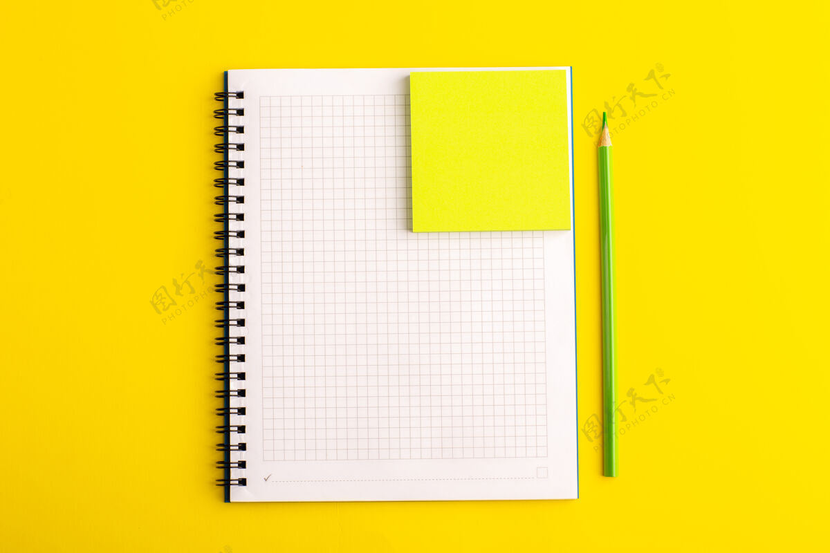 孩子正面视图打开黄色书桌上的黄色贴纸的抄写本学校笔记打开