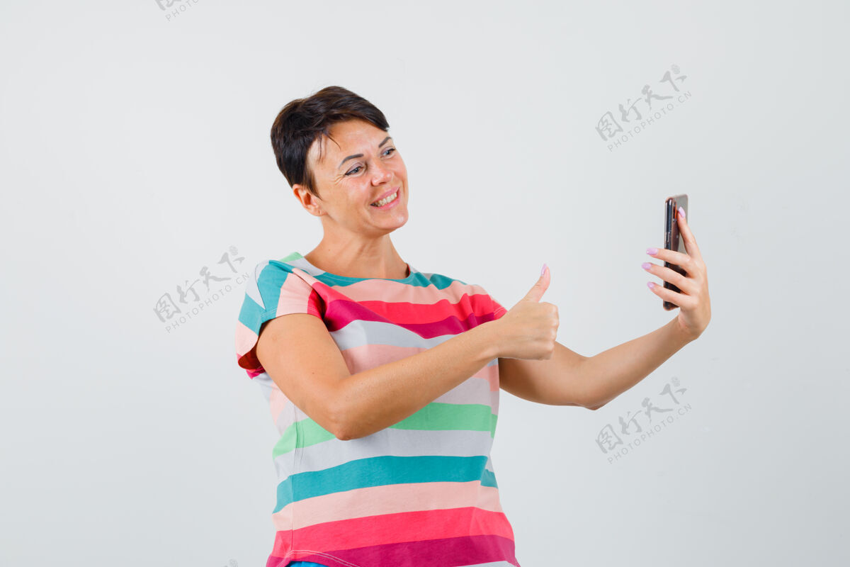 疾病穿着条纹t恤的女性在视频聊天中竖起大拇指 看起来很开心 正面视图医院肖像年轻