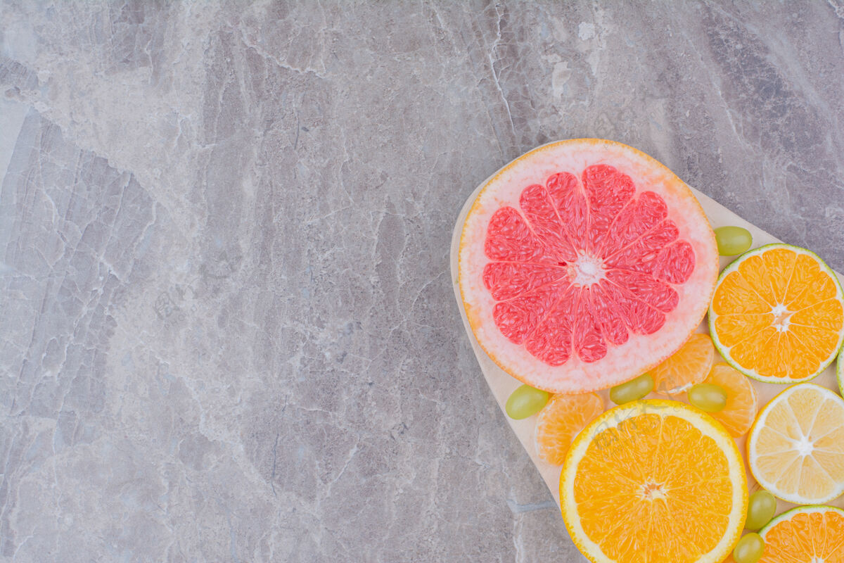 水果柑橘水果片和葡萄放在木板上天然美味柠檬