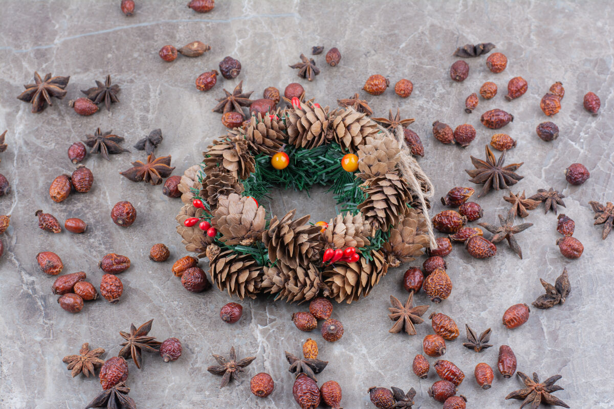 干的圣诞花环与松果和八角星大理石背景玫瑰果圆锥体松果