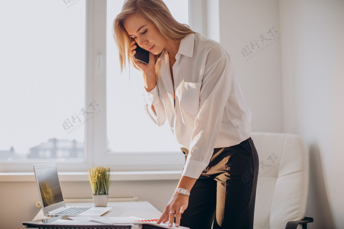 成功年轻的女商人在办公室打电话秘书生活方式的房子迷人