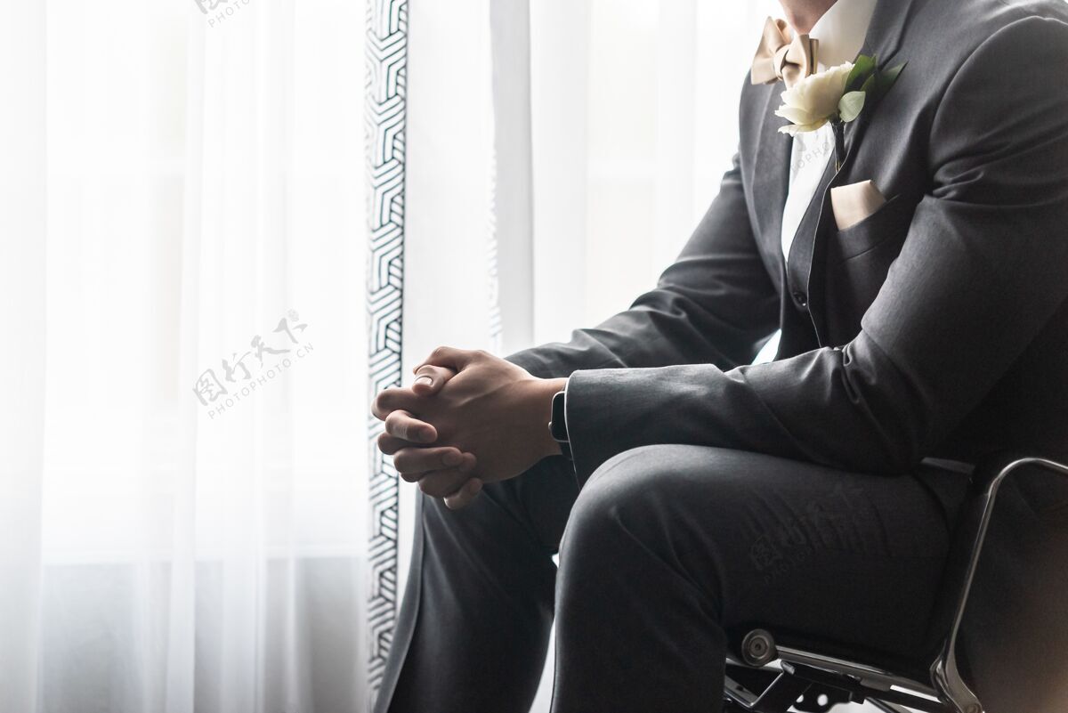 婚礼身着黑色西装的帅哥新郎在婚礼前祈祷花新郎服饰