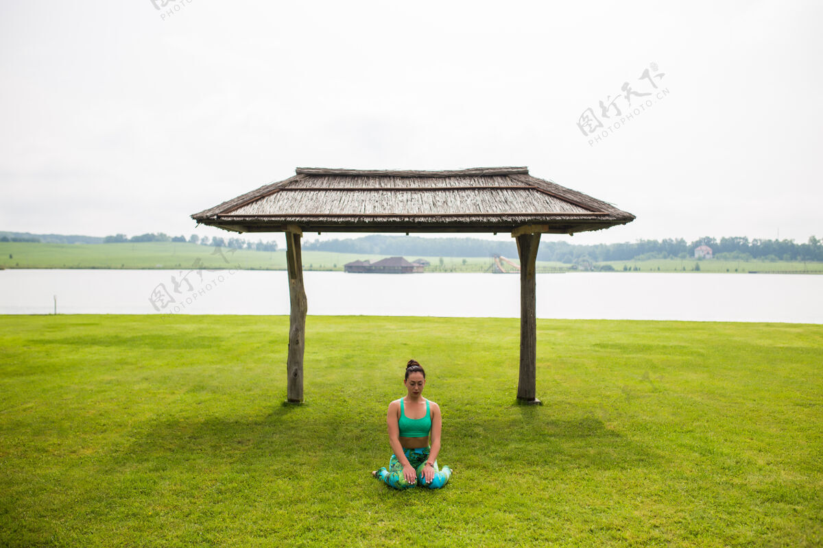 快乐快乐的画像年轻女子在户外练习瑜伽姿势健康私人教练