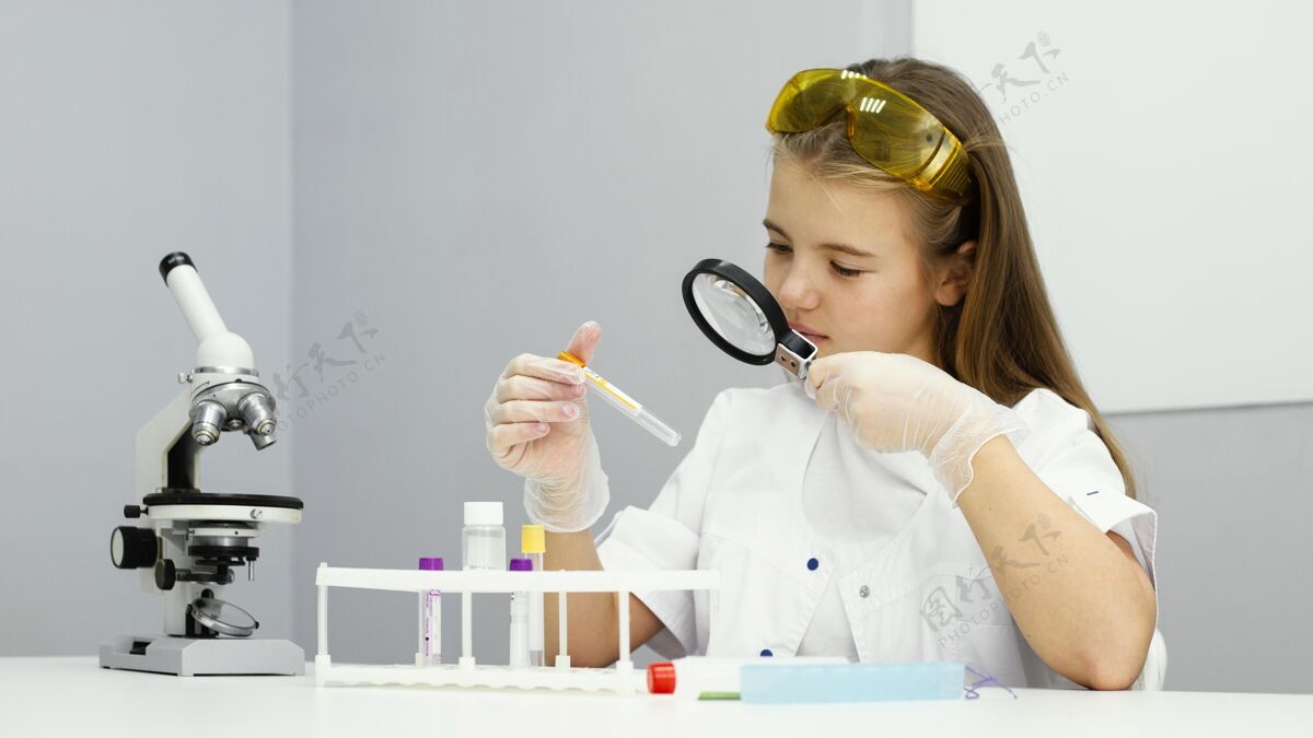 试管带试管和放大镜的女科学家的前视图实验室女孩安全眼镜