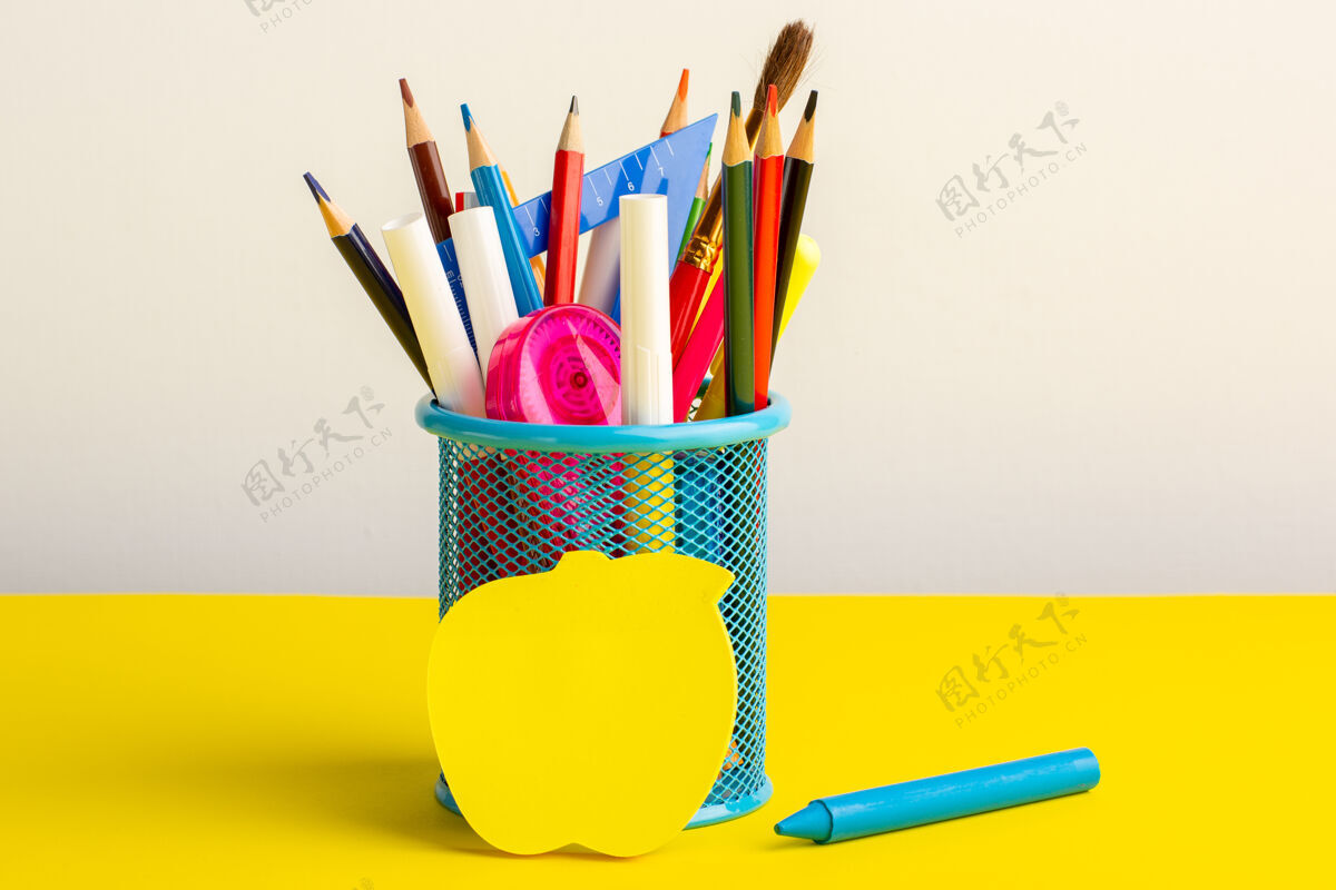 不同黄色书桌上有彩色铅笔和毛毡笔钢笔木材学校