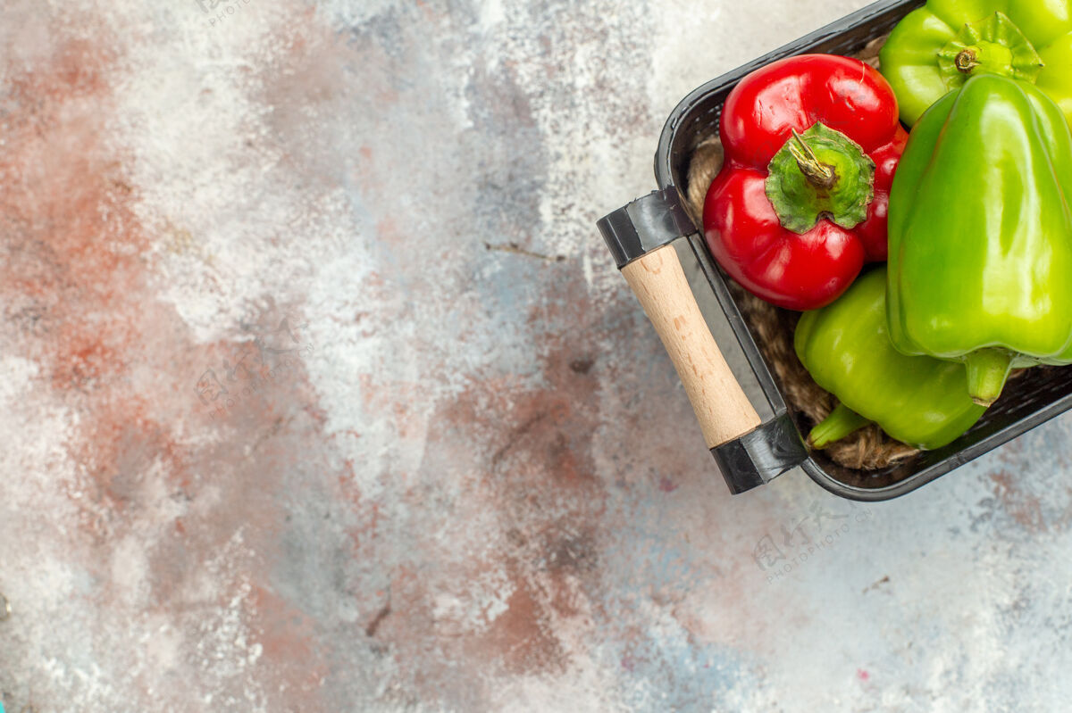 青椒和红椒顶视图绿色和红色辣椒在碗裸体表面与自由空间设备顶部吃苹果