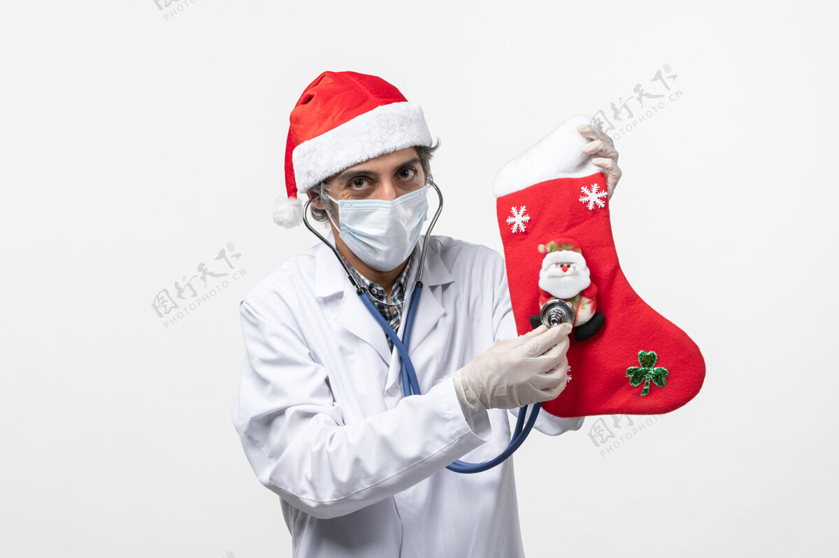 听诊器正面图男医生在白墙上观察节日袜子病毒假日袜子视图外套